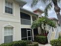 Exterior elevation of a two story condominium with mature landscaping and stairs to the upper units at 7201 L Pavia Blvd # 7201, Venice, FL 34292