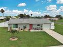Charming single-story home featuring a manicured lawn and beautiful landscaping at 7505 Wexford St, North Port, FL 34287
