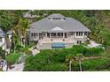 Aerial view of the home showcasing a swimming pool, balconies, lush greenery and architecture at 755 Eagle Point Dr, Venice, FL 34285