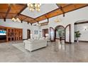 Spacious living room with high ceilings, wood beams, tile floors, and large windows at 755 Eagle Point Dr, Venice, FL 34285