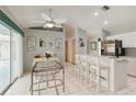 Bright kitchen with stainless steel appliances, white cabinetry, bar seating and breakfast nook with a glass table at 1110 Southlake Ct, Venice, FL 34285