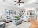 Bright living room with coastal decor, plush white sofas, blue accents, and an open view to the kitchen at 1164 Beachcomber Ct # 19, Osprey, FL 34229
