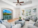 Cozy living room with comfortable seating, entertainment center, plantation shutters, and tile flooring at 1164 Beachcomber Ct # 19, Osprey, FL 34229