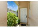 Inviting front entrance with a white door, landscaping and a cozy front porch at 11954 Tempest Harbor Loop, Venice, FL 34292