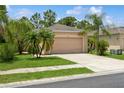 Charming single-story home with a well-manicured lawn, palm trees and a two-car garage at 11954 Tempest Harbor Loop, Venice, FL 34292