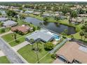 Breathtaking aerial view of property with a pool, backing to a serene lake, surrounded by lush greenery at 120 Hourglass Dr, Venice, FL 34293