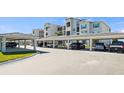 Image of covered parking area with several cars parked underneath at condo complex at 12140 Wellen Golf St # 202, Venice, FL 34293