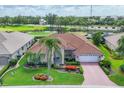 Beautiful aerial view of home showing the tile roof, landscaping, and golf course community at 1345 Reserve Dr, Venice, FL 34285