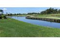 Scenic water view with a wooden bridge and lush green landscaping in a serene golf course setting at 1345 Reserve Dr, Venice, FL 34285