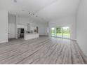 Spacious open-concept living room with wood flooring and sliding glass doors at 137 Mariner Ln, Rotonda West, FL 33947