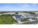 Stunning aerial view of a pristine home near a tranquil lake and lush surroundings at 18136 Foxtail Loop, Venice, FL 34293