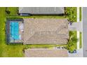 Aerial view of a home with screened pool, manicured lawn and mature trees at 19927 Bridgetown Loop, Venice, FL 34293