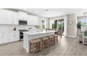 Bright kitchen features white cabinetry, stainless appliances, and a large island with seating at 19927 Bridgetown Loop, Venice, FL 34293