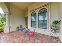 Inviting front porch area with a seating arrangement and arched windows at 20169 Cristoforo Pl, Venice, FL 34293