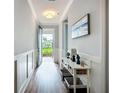 Hallway with a decorative table and a view of the front yard through the glass door at 20749 Swallowtail Ct, Venice, FL 34293