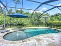 Screened pool area featuring a sparkling pool with a water feature, hot tub, and outdoor dining space at 20749 Swallowtail Ct, Venice, FL 34293