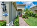 Inviting front entrance featuring a brick walkway, address plaque, and lush landscaping at 21641 Winter Park Ct, Venice, FL 34293