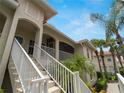 Staircase leading to a condo entrance with white railings and tropical landscaping on a sunny day at 2204 L Pavia Blvd # 2204, Venice, FL 34292