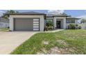 Beautiful home showcasing modern architectural style with a two car garage, manicured lawn and decorative landscaping at 2245 Pickard Ln, North Port, FL 34286