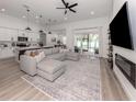 Open-concept living room featuring a large comfortable sectional sofa, adjacent to the modern kitchen and dining area at 2245 Pickard Ln, North Port, FL 34286