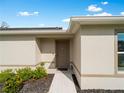 Inviting front entrance featuring a well-maintained walkway, neutral paint, and manicured landscaping at 2355 Allsup Ter, North Port, FL 34286