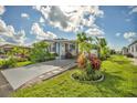 Inviting single-story home featuring a lush, green lawn, mature landscaping, and a concrete driveway at 239 Cutter Ct, North Port, FL 34287