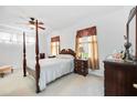 Comfortable bedroom with carpet flooring, ceiling fan, and ample natural light at 24536 Buckingham Way, Port Charlotte, FL 33980
