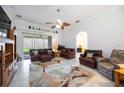 Bright living room with tile flooring, archway, and sliding glass doors to the lanai at 24536 Buckingham Way, Port Charlotte, FL 33980