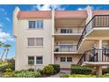 A three-story condo building with a red tile roof and black iron railings, surrounded by lush landscaping at 250 Santa Maria St # 314, Venice, FL 34285