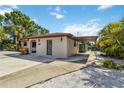 A cozy home showcasing a carport and gravel landscaping for low maintenance, with a glimpse of a fenced backyard at 2555 Yucca Rd, Venice, FL 34293