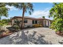 Quaint home featuring easy-care landscaping with gravel, offering a clean and modern look to the front yard at 2555 Yucca Rd, Venice, FL 34293