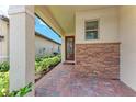 Covered entrance with brick paving and stone accents by front door at 257 Teramo Way, Nokomis, FL 34275