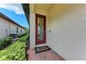Front door with decorative glass and sidelight is accessible from a brick paved walkway at 257 Teramo Way, Nokomis, FL 34275