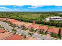 Aerial view of a residential neighborhood featuring well-maintained homes, red tiled roofs, and lush greenery at 260 Soliera St, Nokomis, FL 34275