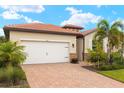 Inviting single-story home with a brick driveway, two-car garage, and beautifully landscaped front yard at 260 Soliera St, Nokomis, FL 34275