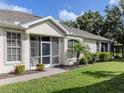 Well-maintained home with screened entry, complemented by lush landscaping and a brick walkway at 29704 Niagara Court, Englewood, FL 34223