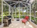 Enclosed patio with grill, chair, and spacious area, perfect for relaxation and outdoor enjoyment at 29704 Niagara Court, Englewood, FL 34223