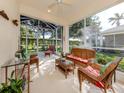 Inviting screened lanai featuring comfortable seating and a ceiling fan for outdoor relaxation at 29704 Niagara Court, Englewood, FL 34223