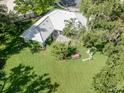 A sprawling backyard offers lush green space, mature trees, and a charming seating area at 337 Meadow Beauty Ct, Venice, FL 34293