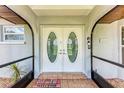 Inviting double front doors with tiled entryway and a 'Welcome' mat at 3376 Peace River Dr, Punta Gorda, FL 33983