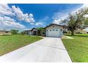 Exterior of lovely home featuring an expansive driveway leading up to the detached garage at 3376 Peace River Dr, Punta Gorda, FL 33983