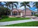Lovely home with well-manicured lawn and mature palm trees enhancing curb appeal at 4308 Via Del Santi, Venice, FL 34293
