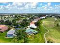 Aerial view of home near a golf course with pool and lush landscaping in a vibrant community at 467 Sherbrooke Ct, Venice, FL 34293