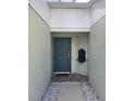 Close-up of the blue front door and welcome mat with small plants to add charm at 482 Pendleton Pl, Venice, FL 34292