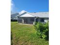 View of screened-in lanai with neutral decor overlooking green lawn and backyard at 482 Pendleton Pl, Venice, FL 34292