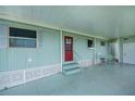Welcoming covered patio with blue flooring, offering a relaxing outdoor space with two chairs and an entry door at 527 Walnut Cir, Venice, FL 34285