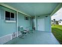 Relaxing covered patio featuring cool blue flooring, comfortable seating, and easy access to the outdoors at 527 Walnut Cir, Venice, FL 34285