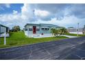 Inviting single-story home with a well-kept lawn, red front door, and convenient carport at 527 Walnut Cir, Venice, FL 34285