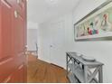 Inviting foyer with wood floors, grey shelving, and a decorative painting at 5459 Bentgrass Dr # 2-304, Sarasota, FL 34235