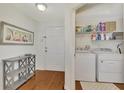 Hallway view of the laundry area with modern machines, shelving, and storage at 5459 Bentgrass Dr # 2-304, Sarasota, FL 34235